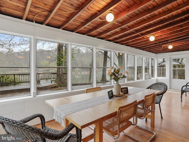 sunroom / solarium with outdoor dining area, wood ceiling, beam ceiling, and wood finished floors
