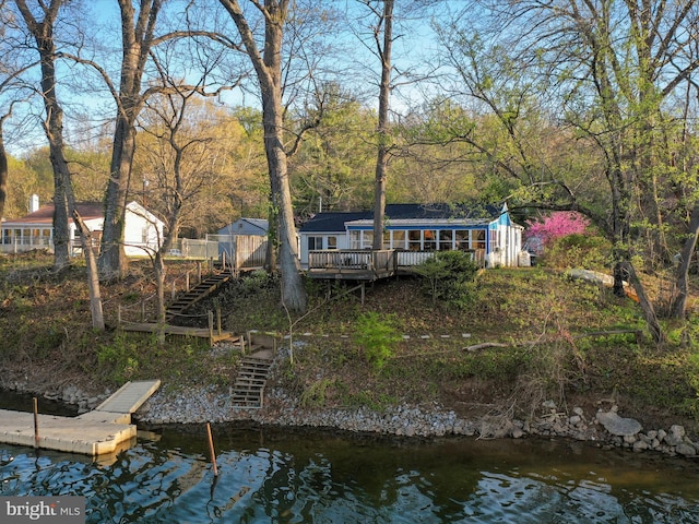 rear view of house featuring a deck with water view and stairs