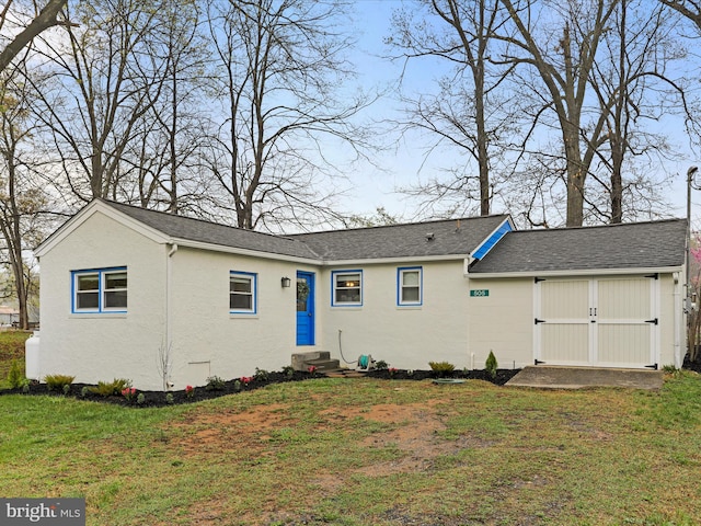 view of front of home with a front yard, entry steps, stucco siding, and a shingled roof