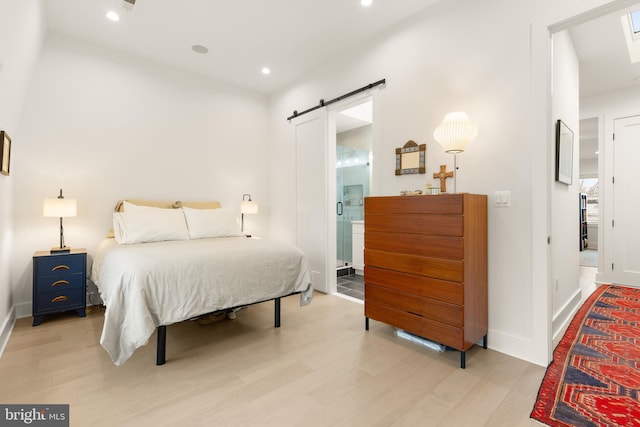 632 Rock Creek Church Rd NW Unit 2, Washington, DC 20010 - bedroom featuring a barn door, wood finished floors, recessed lighting, and connected bathroom