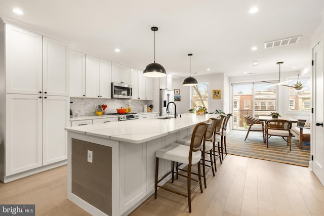 632 Rock Creek Church Rd NW Unit 2, Washington, DC 20010 - kitchen featuring stainless steel appliances, light wood-style flooring, white cabinetry, a large island, and recessed lighting