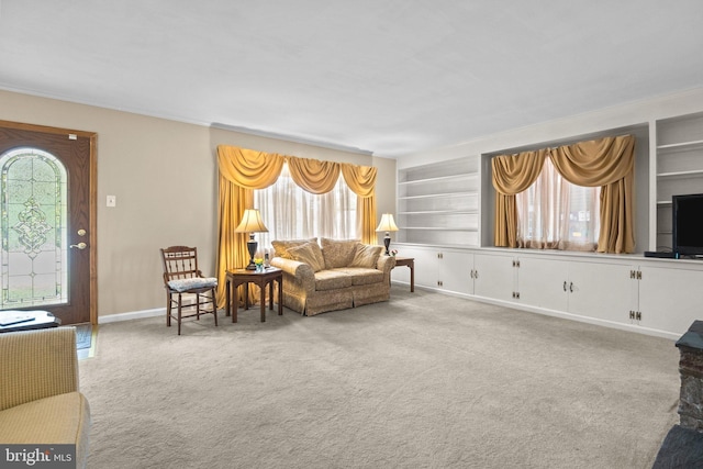 carpeted living area with built in features and baseboards