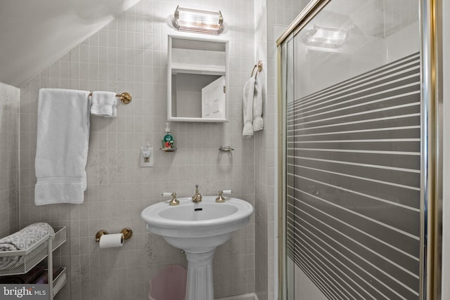 full bathroom featuring tile walls, a stall shower, and lofted ceiling