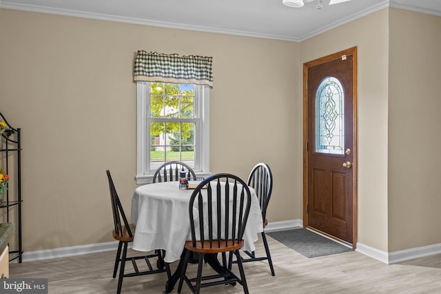 dining space with light wood-style floors, baseboards, and ornamental molding