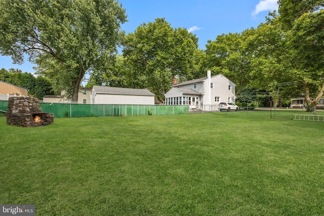 view of yard with a fenced backyard and an outdoor stone fireplace