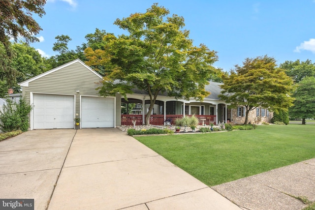 view of front facade featuring a front yard, covered porch, and driveway