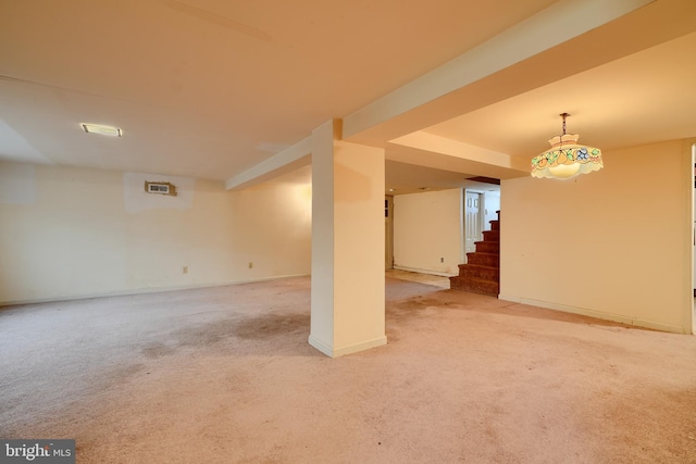 finished below grade area with carpet flooring, baseboards, and stairway