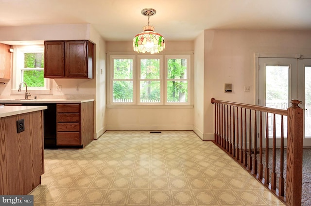 kitchen featuring a sink, light countertops, baseboards, and light flooring