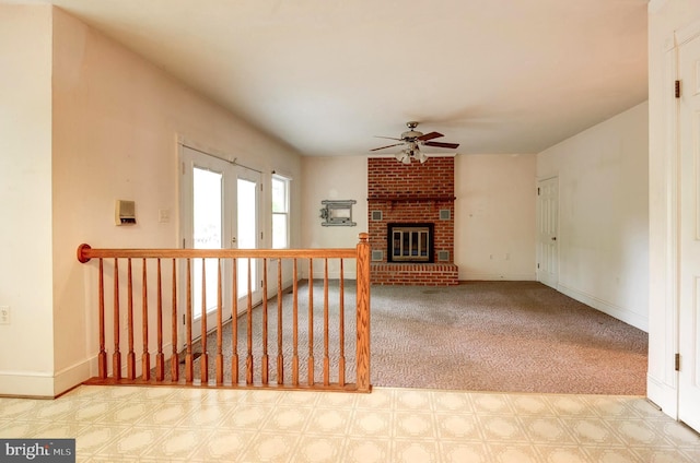 unfurnished living room featuring ceiling fan, tile patterned floors, a brick fireplace, and baseboards