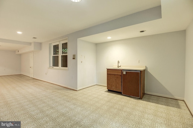 spare room with recessed lighting, baseboards, and wet bar