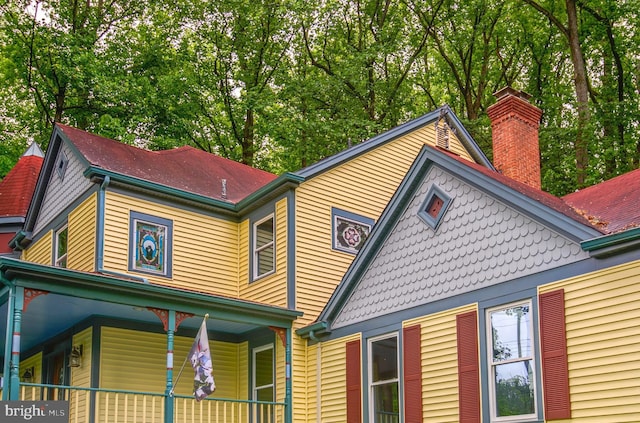 view of front of property featuring a chimney and a porch