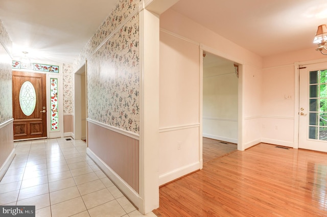 entrance foyer with wainscoting, baseboards, wallpapered walls, and tile patterned flooring
