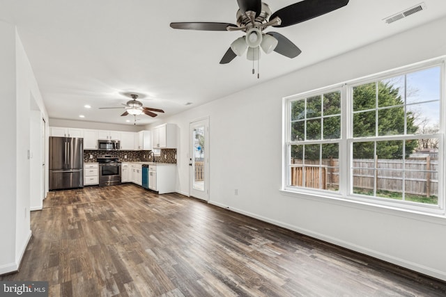kitchen with visible vents, stainless steel appliances, a ceiling fan, and tasteful backsplash