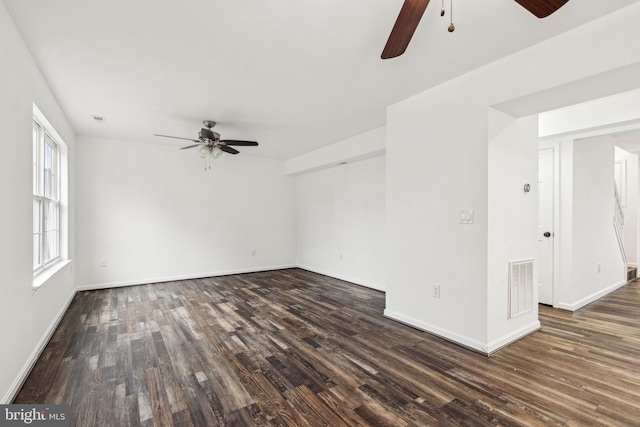 unfurnished room featuring visible vents, dark wood-style floors, baseboards, and ceiling fan