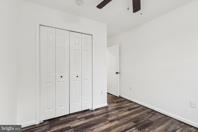 unfurnished bedroom with a ceiling fan, baseboards, a closet, and dark wood finished floors