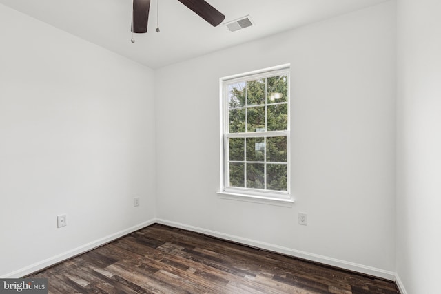 spare room with a healthy amount of sunlight, visible vents, dark wood-type flooring, and a ceiling fan