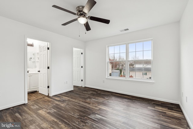 unfurnished bedroom featuring dark wood-type flooring, baseboards, and visible vents
