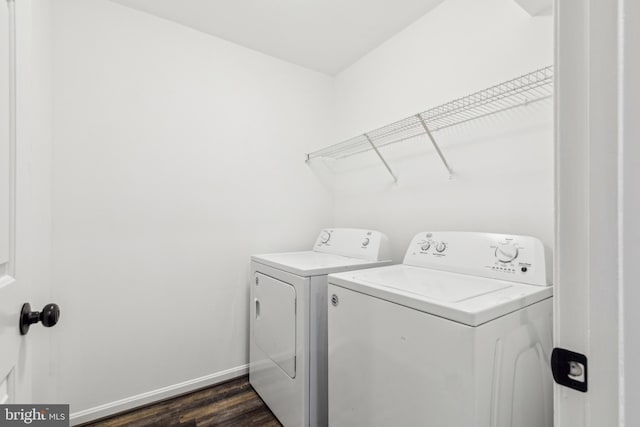 laundry area featuring washing machine and clothes dryer, baseboards, laundry area, and dark wood finished floors