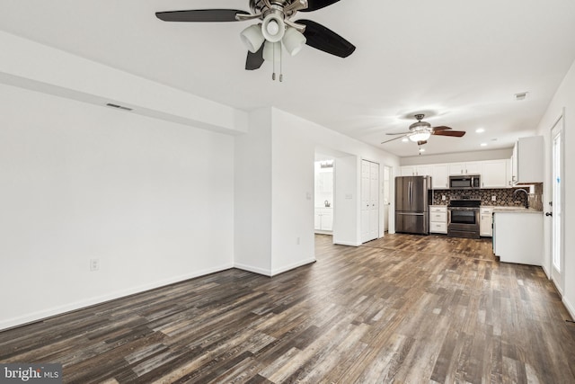 unfurnished living room with baseboards, a sink, dark wood-style floors, visible vents, and ceiling fan