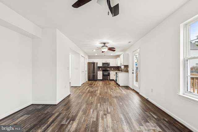 unfurnished living room featuring a ceiling fan, dark wood-type flooring, and baseboards