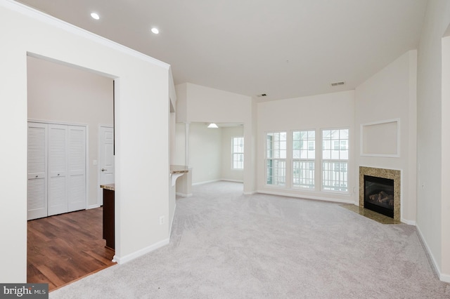 5207 Wyndholme Cir Unit 402, Baltimore, MD 21229 - unfurnished living room featuring carpet flooring, baseboards, a fireplace with flush hearth, and visible vents