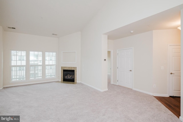 5207 Wyndholme Cir Unit 402, Baltimore, MD 21229 - unfurnished living room featuring carpet flooring, baseboards, a fireplace with flush hearth, and visible vents