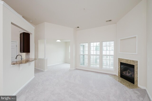 5207 Wyndholme Cir Unit 402, Baltimore, MD 21229 - unfurnished living room with a premium fireplace, light carpet, baseboards, and visible vents