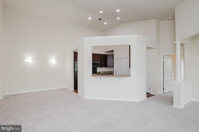 5207 Wyndholme Cir Unit 402, Baltimore, MD 21229 - unfurnished living room with high vaulted ceiling, decorative columns, carpet floors, visible vents, and baseboards