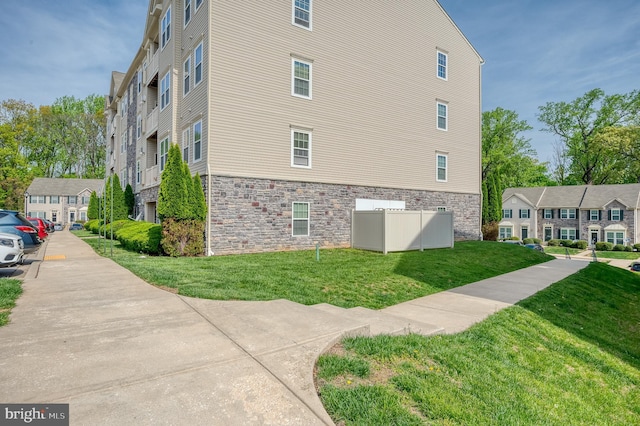 5207 Wyndholme Cir Unit 402, Baltimore, MD 21229 - view of home's exterior featuring a lawn and stone siding
