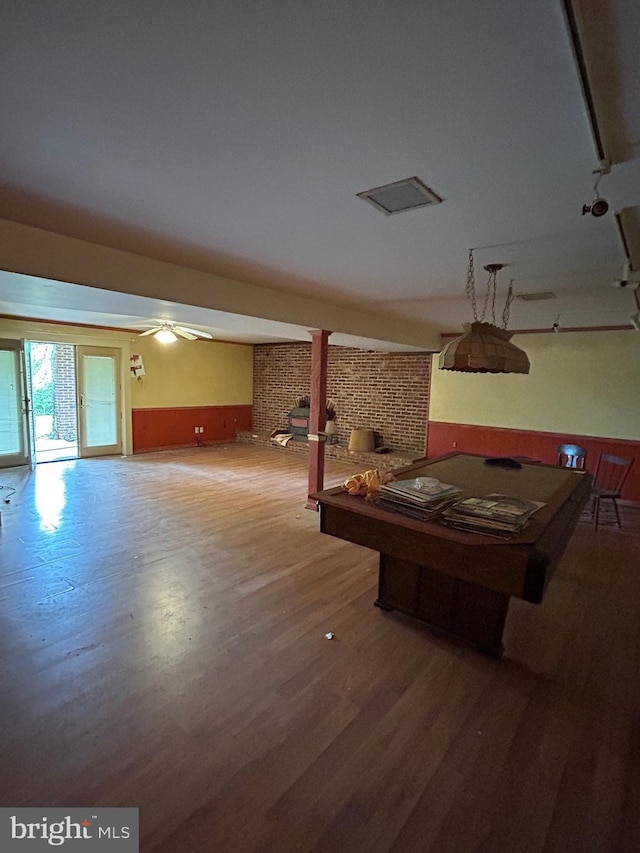 game room with wood finished floors, billiards, and brick wall