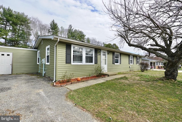 view of front of property featuring gravel driveway and a front lawn