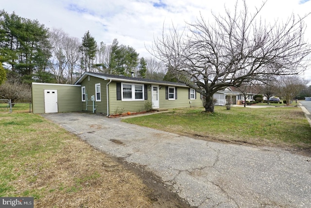 view of front of property featuring aphalt driveway and a front lawn