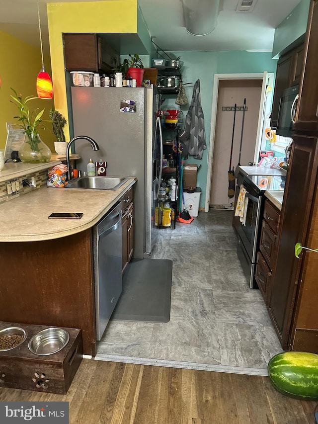 9011 Spring Acres Rd, Clinton, MD 20735 - kitchen with stainless steel appliances, dark brown cabinets, light countertops, and pendant lighting