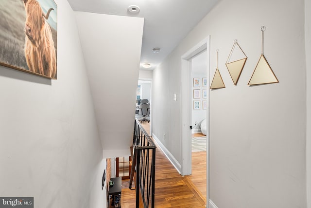corridor with baseboards and wood finished floors