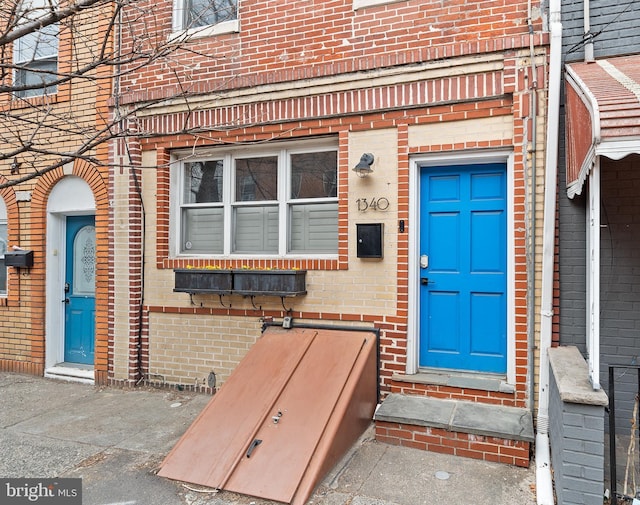 property entrance featuring brick siding