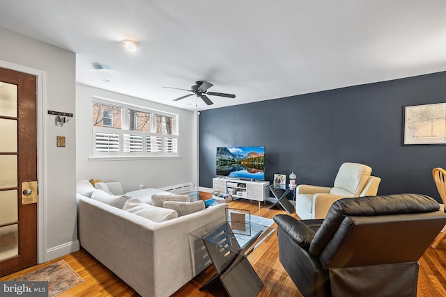 living room with baseboards, ceiling fan, and wood finished floors
