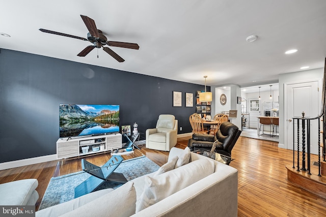 living room featuring baseboards, ceiling fan, wood finished floors, and recessed lighting