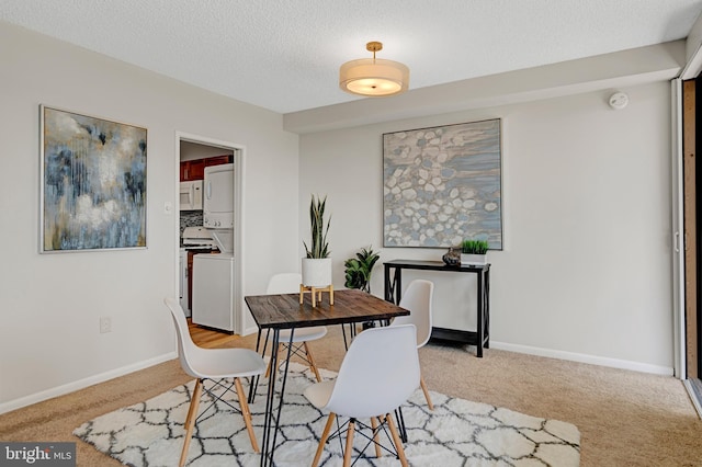 3701 S George Mason Dr Unit 1002N, Falls Church, VA 22041 - dining space with carpet floors, a textured ceiling, baseboards, and stacked washer and clothes dryer