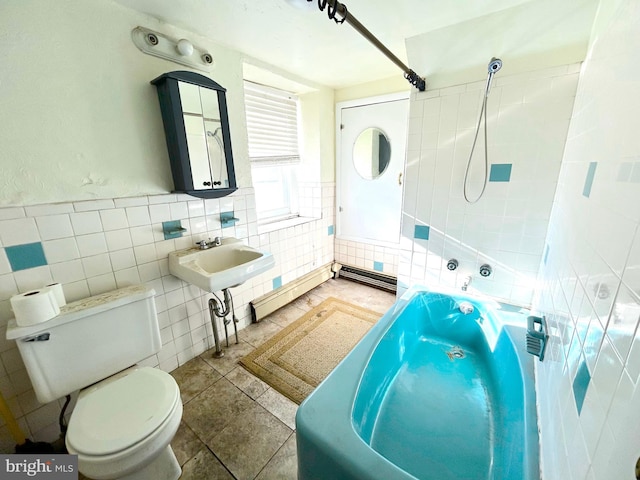 bathroom featuring tile walls, toilet, tile patterned floors, and a sink