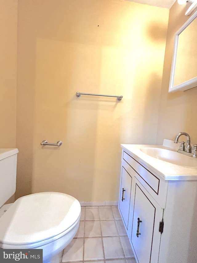 half bathroom featuring toilet, vanity, and tile patterned flooring