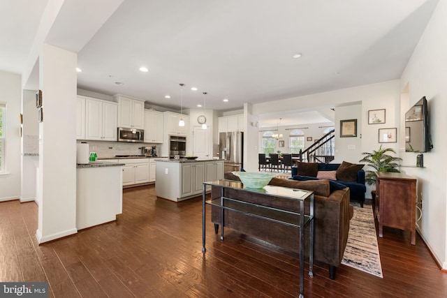 living area with dark wood-style floors, recessed lighting, stairway, and baseboards