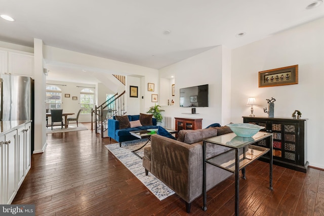 living room featuring baseboards, stairway, and dark wood-style flooring