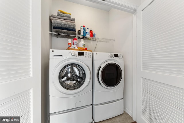 laundry room with tile patterned flooring, washing machine and clothes dryer, and laundry area