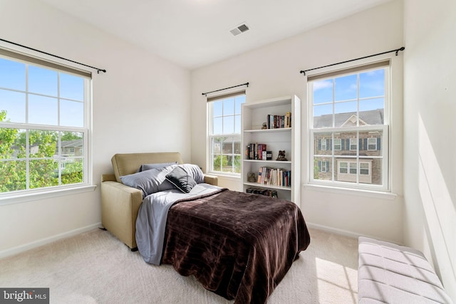bedroom with carpet, visible vents, baseboards, and multiple windows