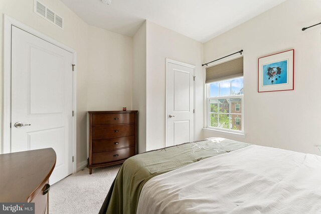 bedroom featuring baseboards, visible vents, and light carpet