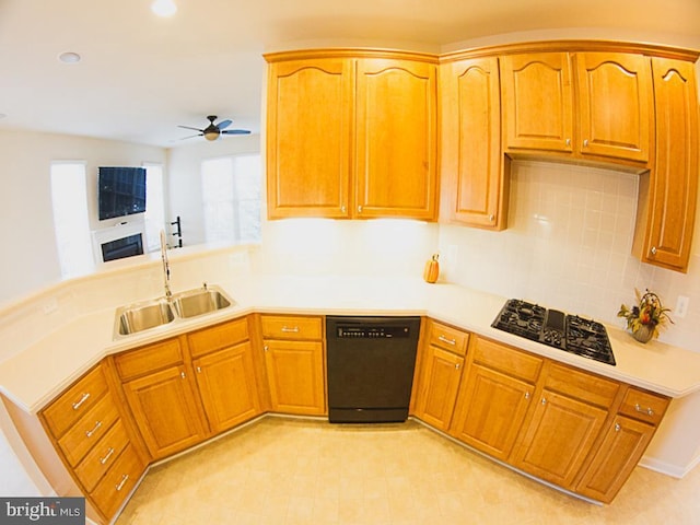 kitchen featuring a ceiling fan, dishwasher, a sink, light countertops, and a peninsula