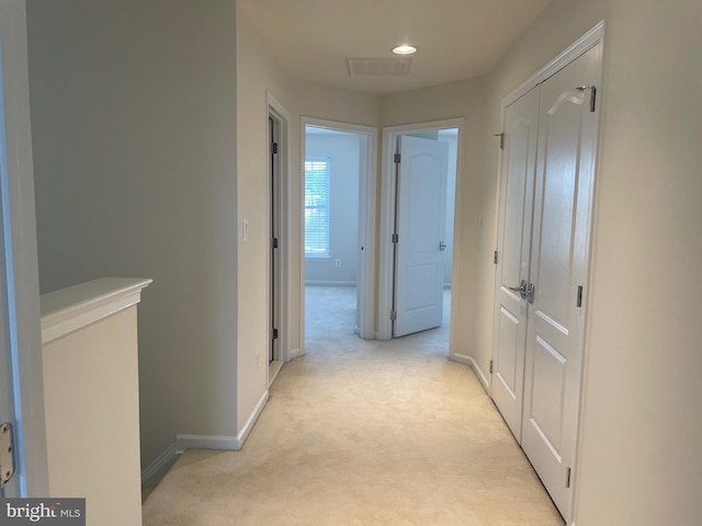corridor featuring baseboards, light carpet, recessed lighting, and visible vents