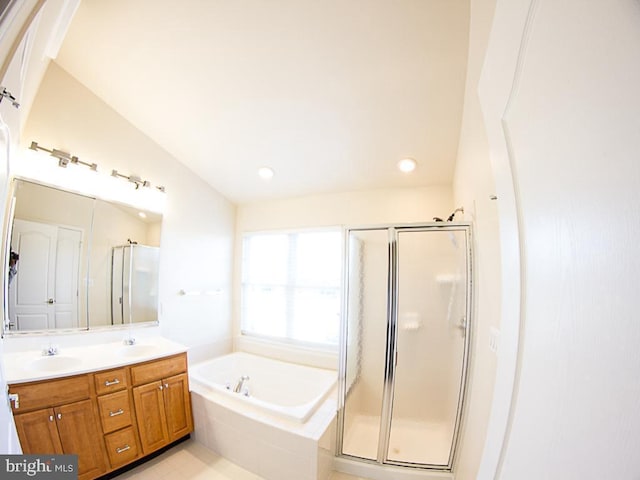full bathroom featuring double vanity, a sink, a garden tub, and a stall shower