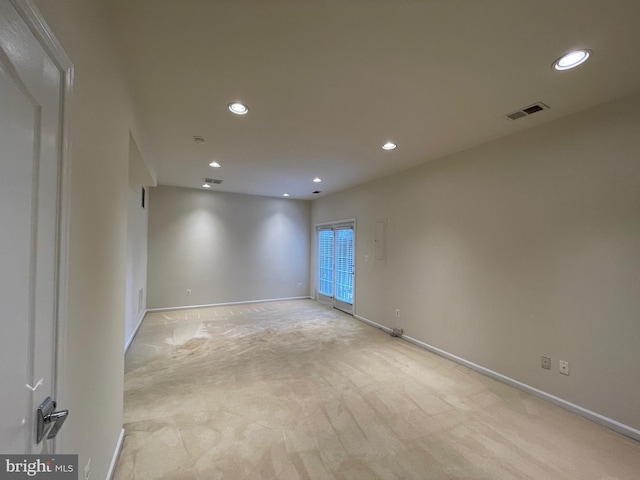 unfurnished room with recessed lighting, baseboards, light colored carpet, and visible vents