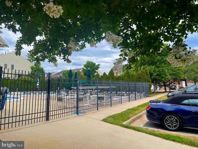 view of property's community with a swimming pool and fence